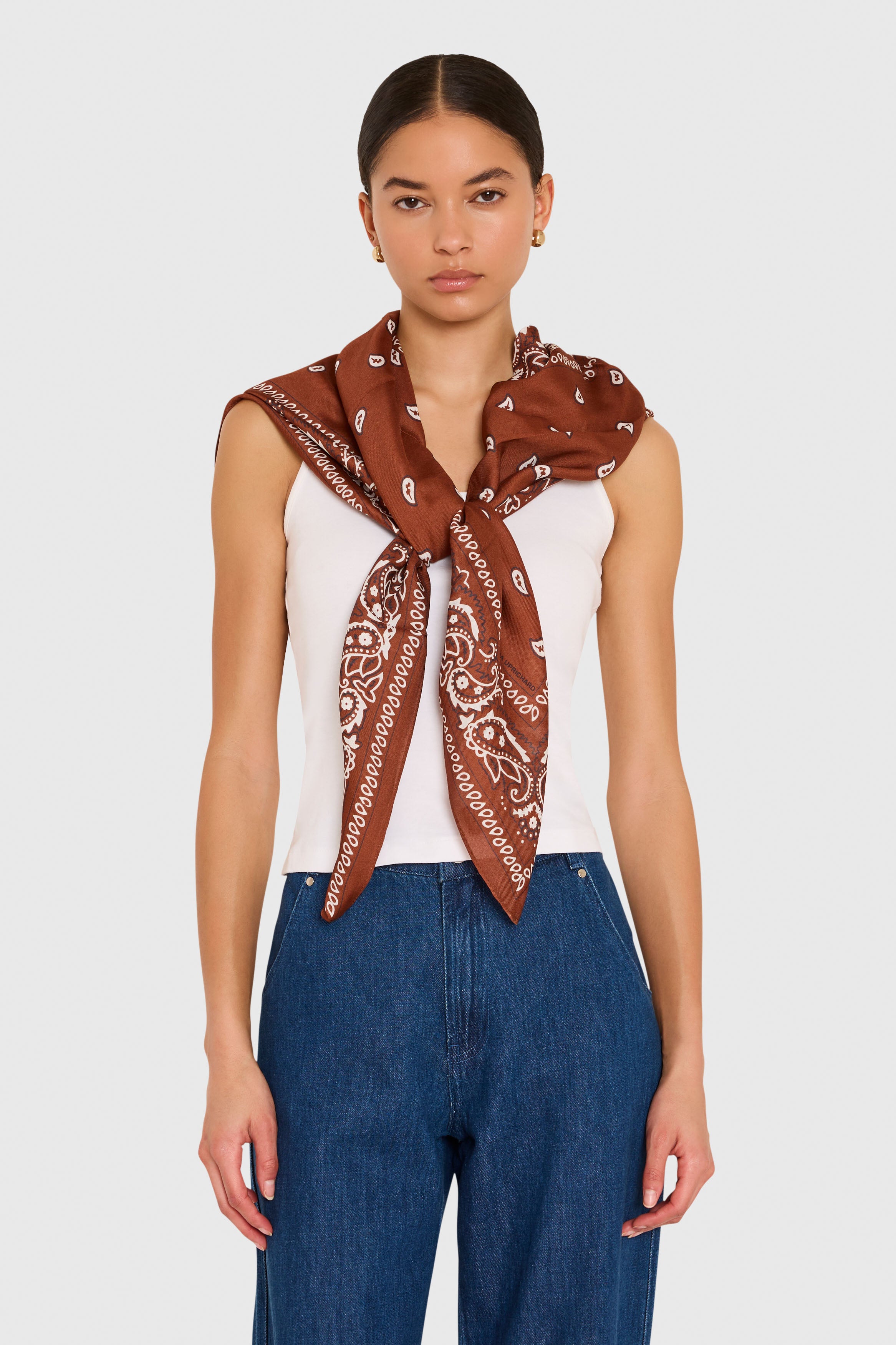 Amanda Uprichard XL Bandana Scarf in Cocoa Brown. Model wears scarf around her shoulders against a white background. 