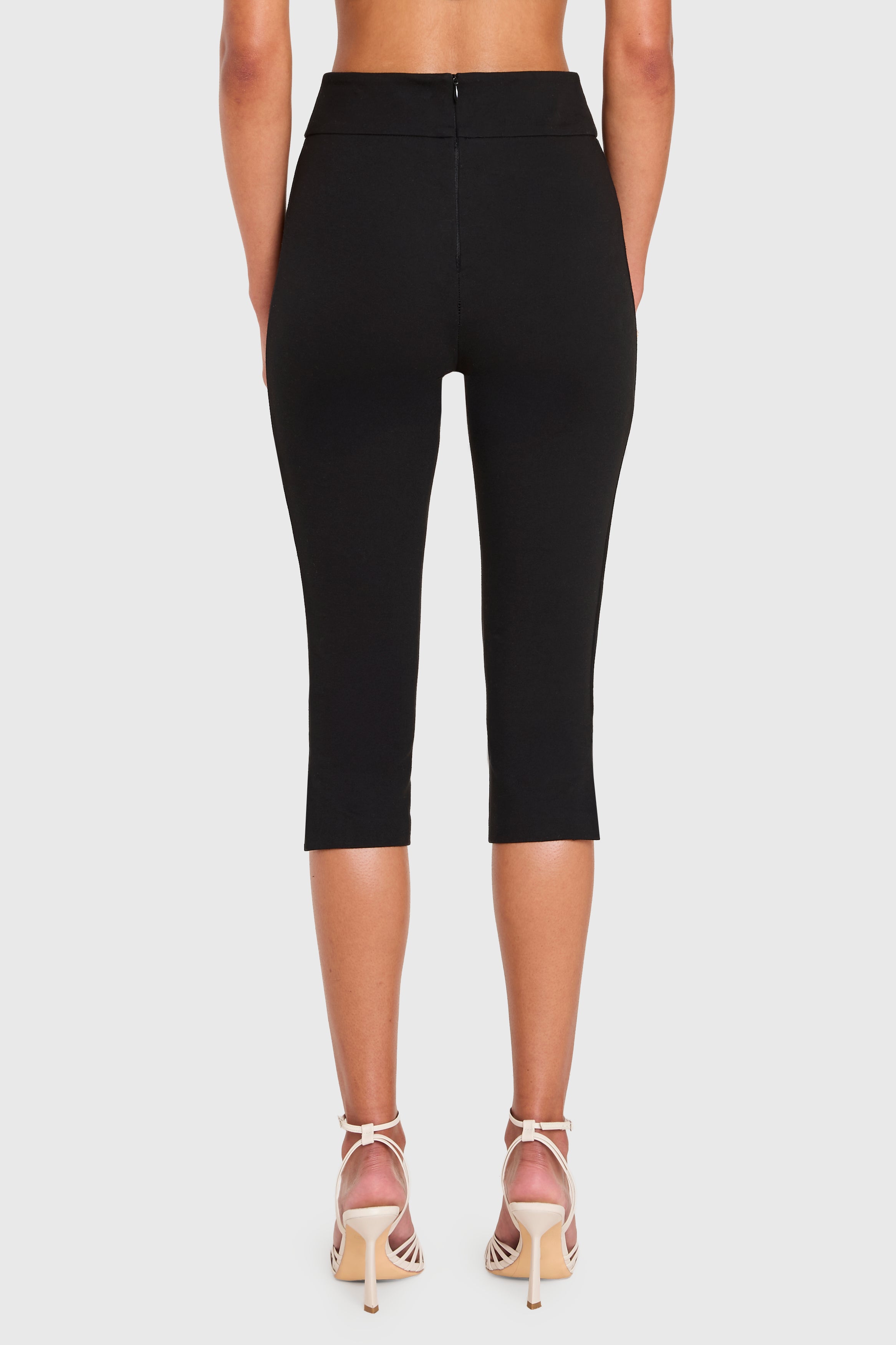 Black capri leggings worn by a person on a white background