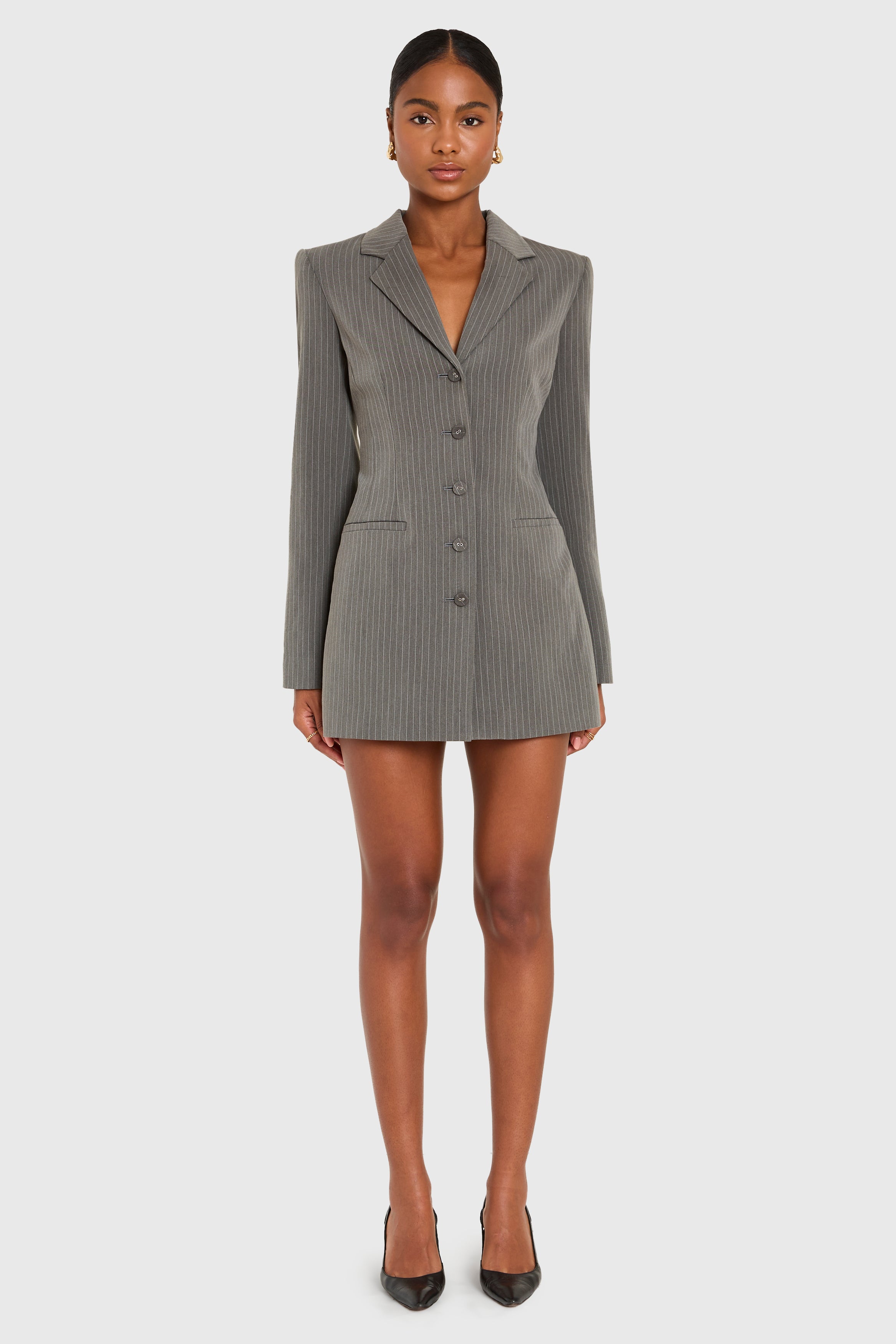 Woman wearing a gray blazer dress on a white background