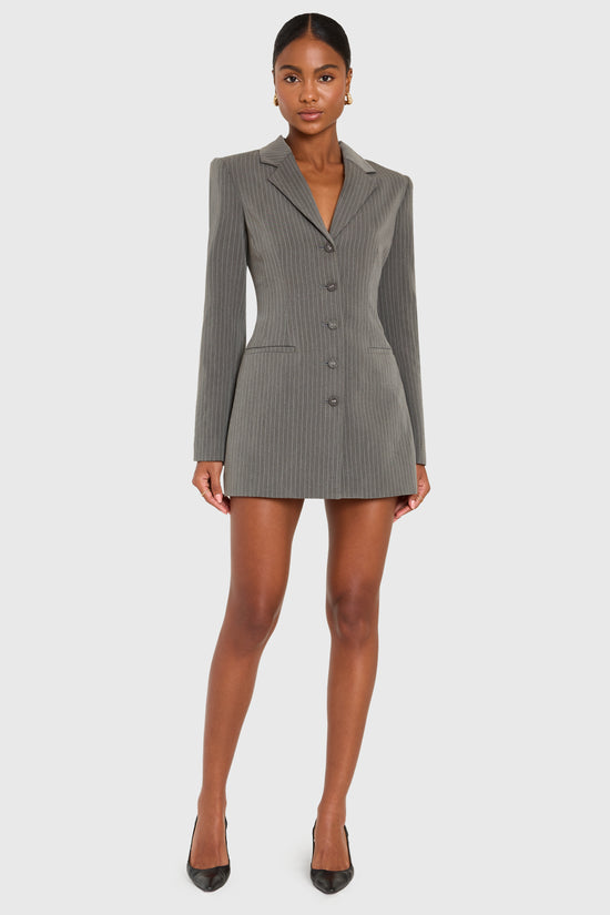 Woman wearing a gray blazer dress on a white background