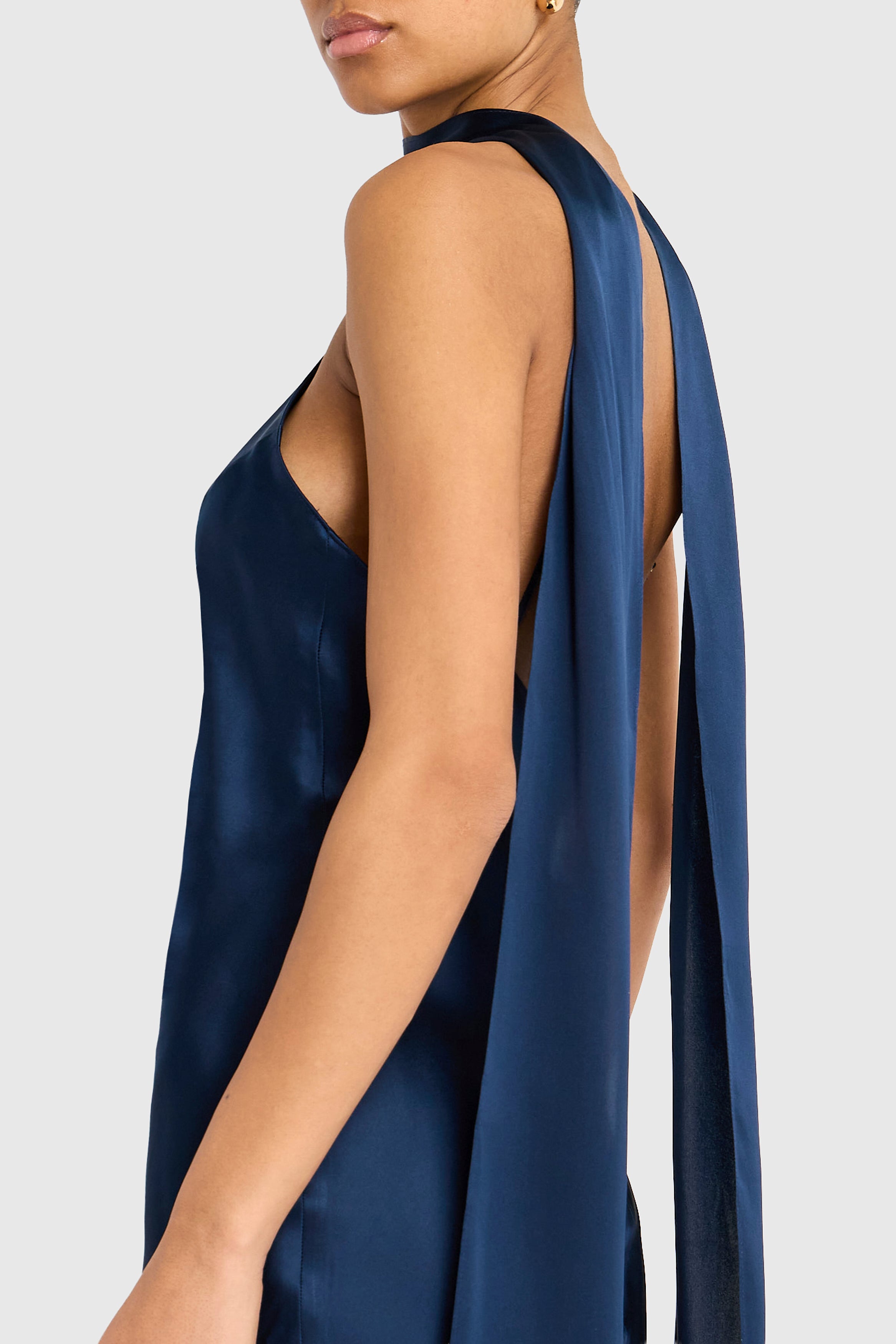 Navy blue satin dress with a draped back on a white background