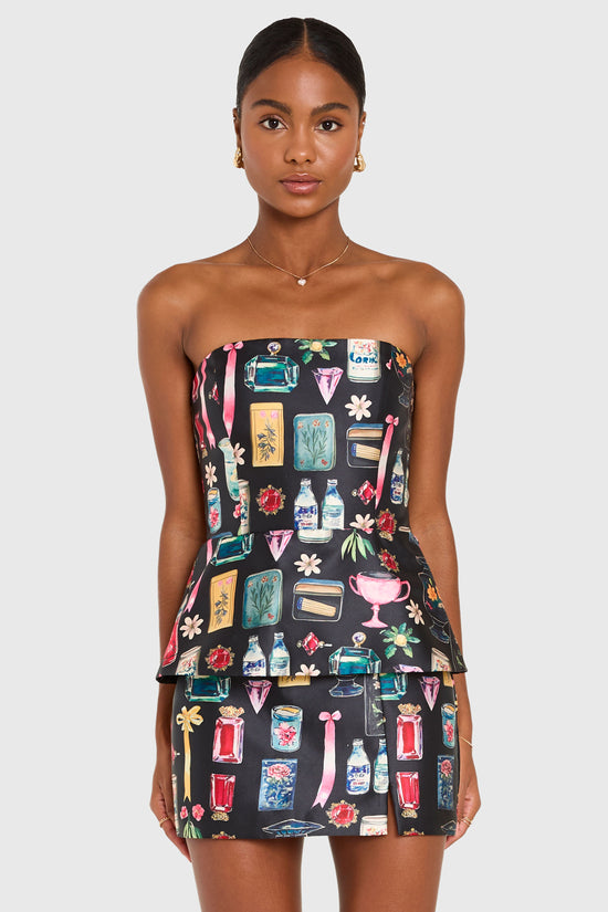 Woman wearing a strapless dress with a colorful pattern on a white background view 1