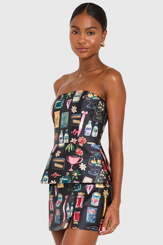 Woman wearing a strapless dress with a colorful pattern on a plain background view 2