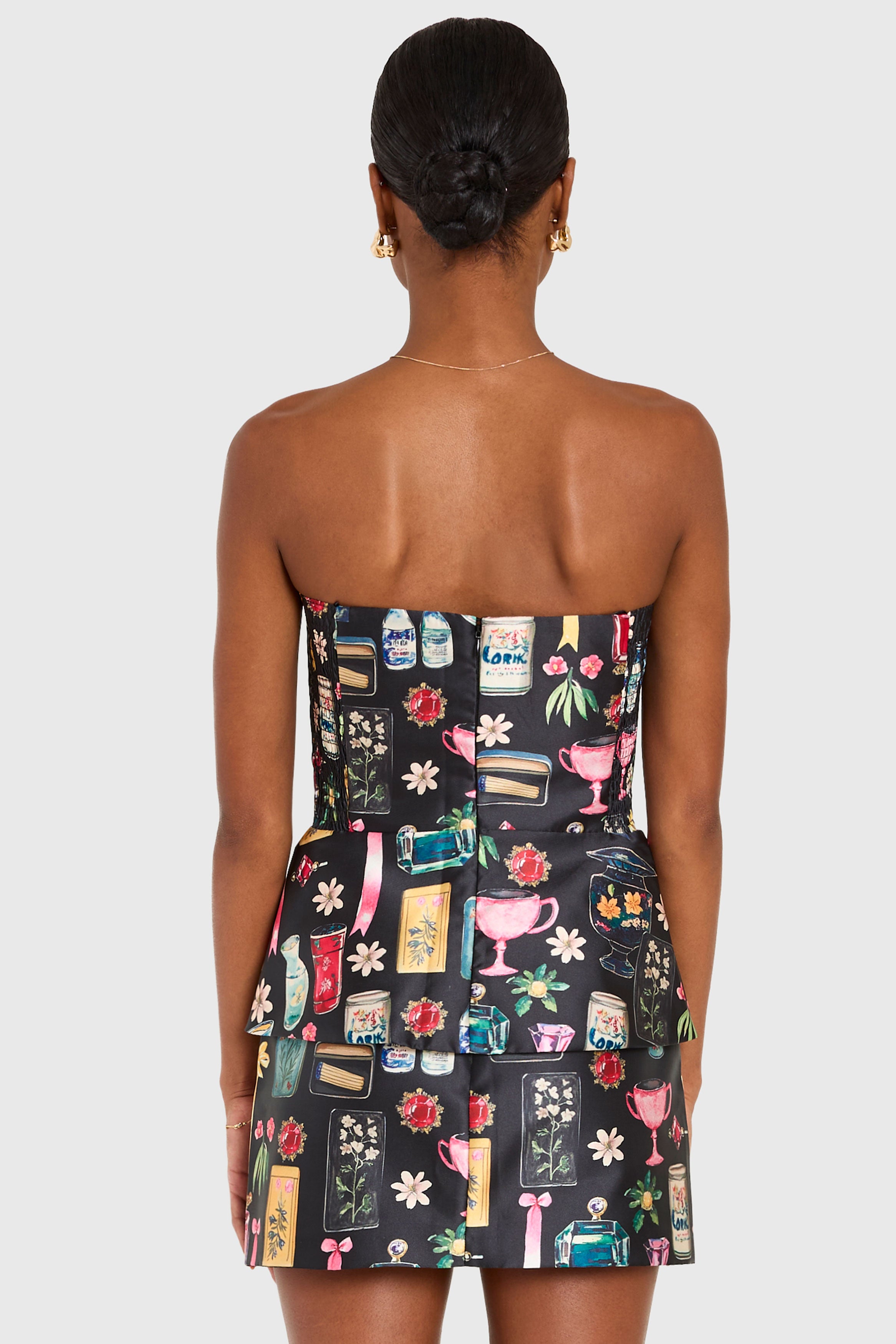 Woman wearing a strapless dress with colorful pattern on a white background