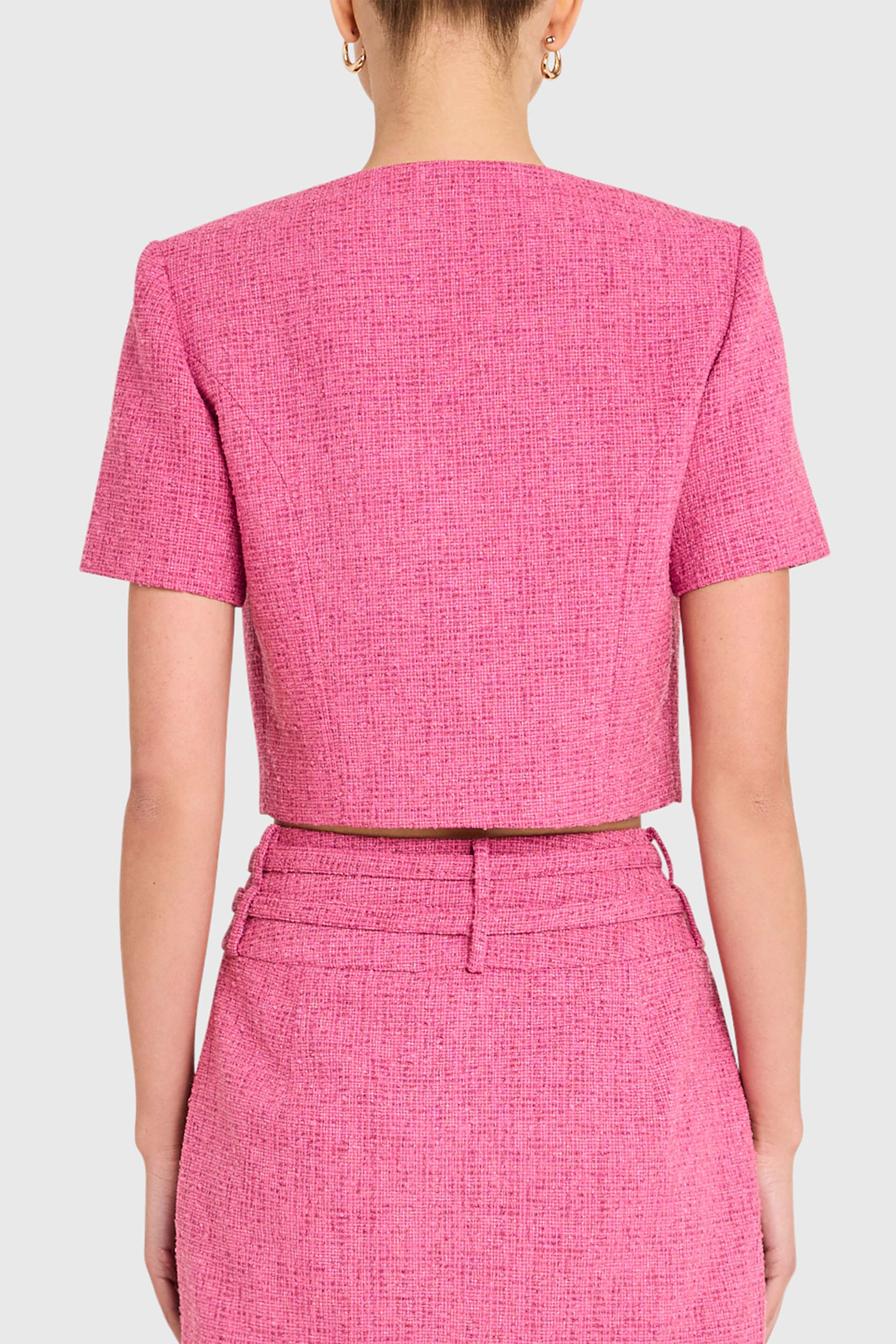 Person wearing a pink textured outfit with a plain background