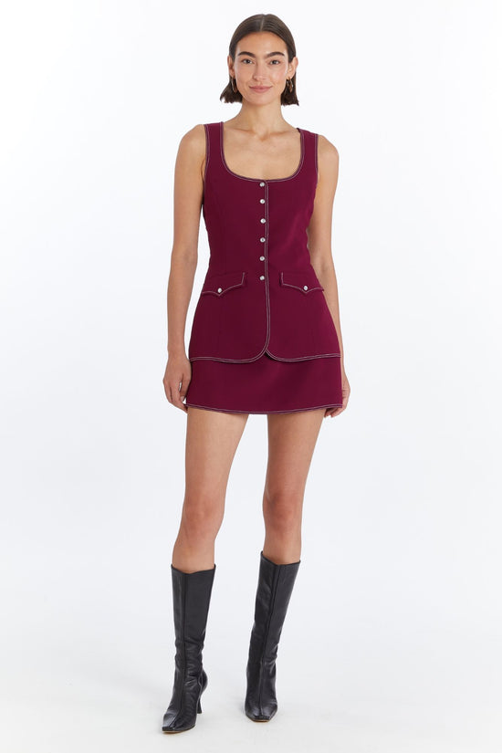 Girl in maroon romper dress, front facing. view 1