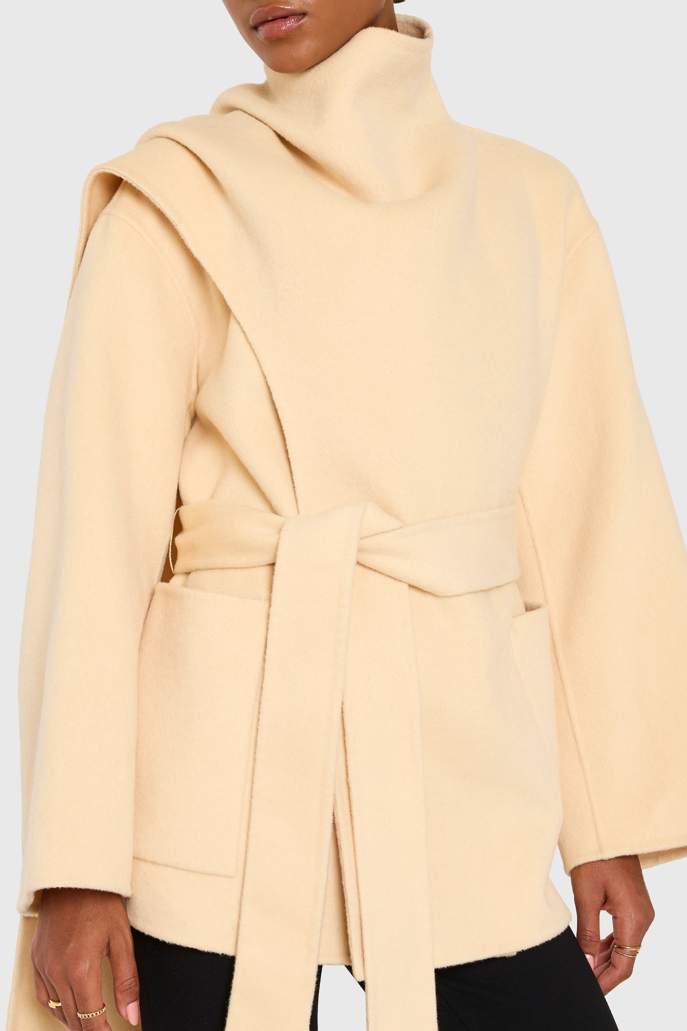 Beige coat worn by a person on a white background